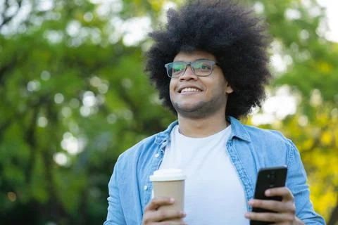 Young man using his mobile phone outdoors. Stock Photos