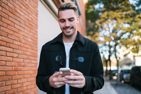 Young man using his mobile phone. Stock Photos