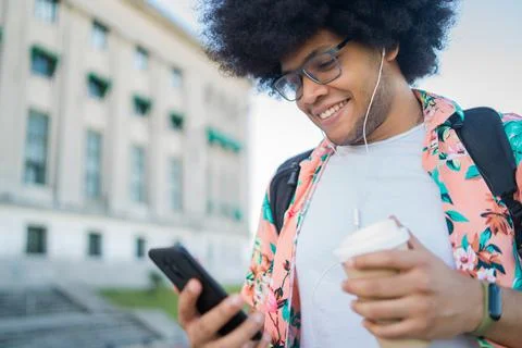Young man using his mobile phone outdoors. Stock Photos