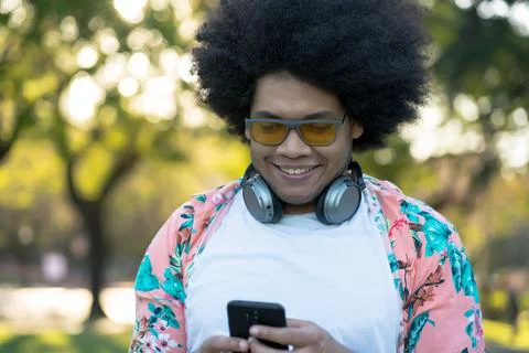 Young man using his mobile phone outdoors. Stock Photos
