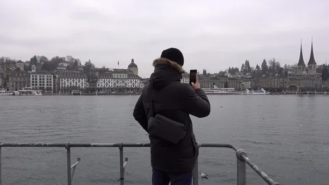 Young Man using his Phone at the Lake Lucerne, Switzerland Stock Footage 122083065