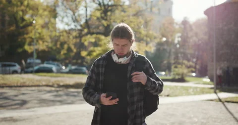 Young man using his phone as he walks on the street. Man is using his Smartphone Stock Footage 195246918