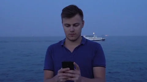 Young man using his smartphone at sea seafront cruise ship motorship background Stock Footage 118305468