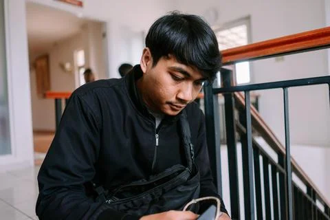 Young man using his smartphone on staircase indoors urban scene Stock Photos