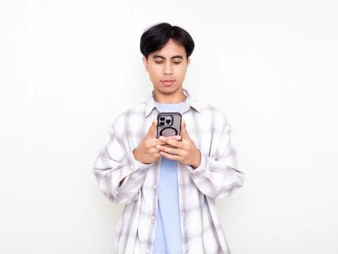 Young man using his smartphone with a serious and focused expression agains.. Stock Photos