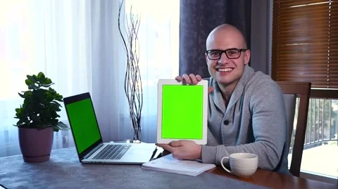Young man using his tablet pc. He is showing the screen. Green screen Stock Footage 61281472