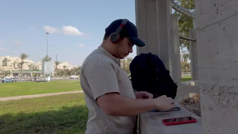 Young man using his tablet in a park on a sunny day. Stock Footage 324926527