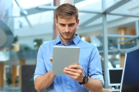 Young man using his tablet in the office. Stock Photos