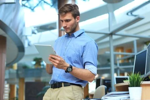 Young man using his tablet in the office. Stock Photos