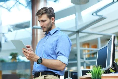 Young man using his tablet in the office. Stock Photos