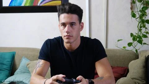Young man using joystick or joypad for videogames Stock Photos