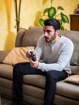 Young man using joystick or joypad for videogames Stock Photos