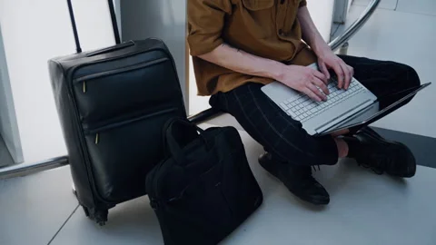 Young man using laptop at airport terminal 库存影片 334561865