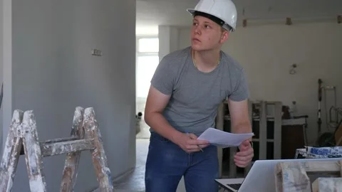 Young man using laptop and verifying papers on part time job in construction Video stock 205591462