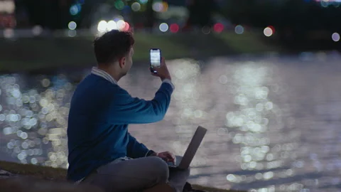 Young Man Using Laptop and Photographing City in the Evening Stock Footage 237054584