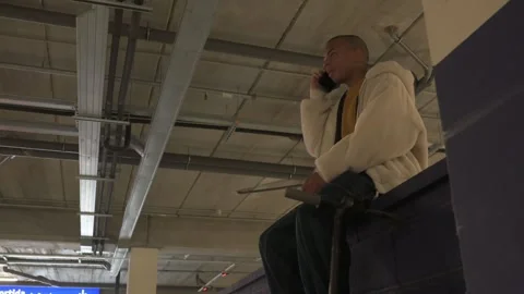 Young man using laptop and smart phone while sitting on a dumpster in a par.. Stock Footage 300334029