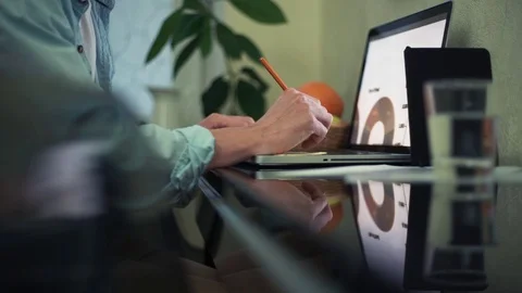 Young man using laptop in cafe. Glass of water, notepad and pencil on table Stock Footage 82937055