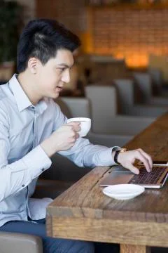 Young man using laptop in cafe Stock Photos