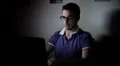 young man using a laptop for chatting on facebook with friends HD Footage