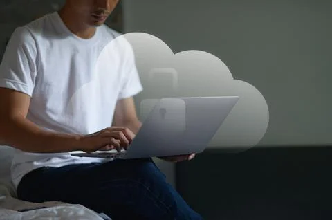 Young Man Using Laptop with Cloud Storage Concept in a Modern Indoor Setting Stock Photos