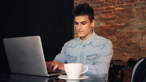Young Man using Laptop Computer at Coffee Shop and smile 스톡 동영상 79036284