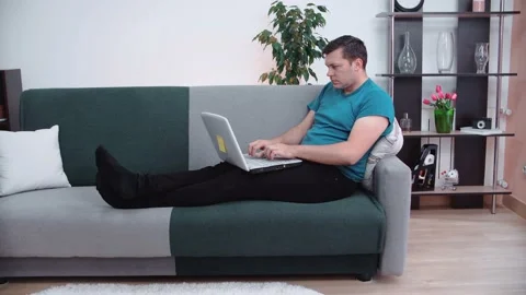 Young man using laptop computer works at home. Freelancer concept. Video stock 148570642