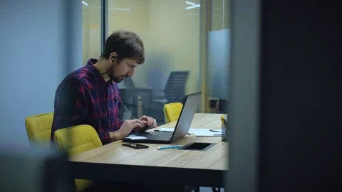 Young man using laptop computer, typing, working in office. Man working on Stock Footage 279085902