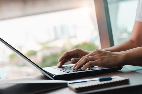 Young man using laptop computer and mobile phone When looking for financial i Stock Photos