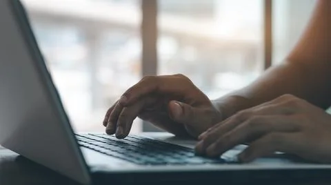 Young man using laptop computer and mobile phone When looking for financial i Stock Photos
