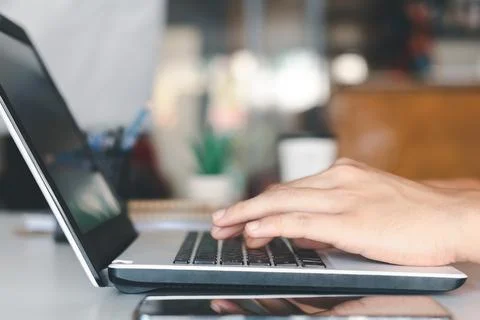 Young man using laptop computer and mobile phone When looking for financial i Stock Photos