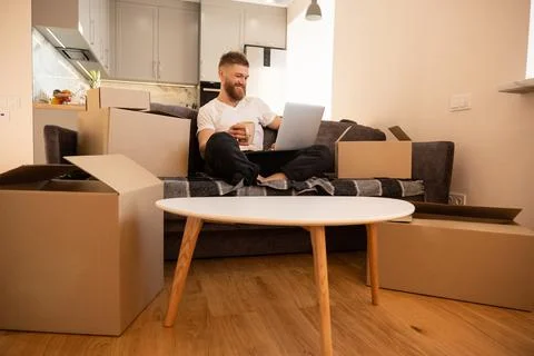 Young man using laptop computer and drinking tea Stock Photos
