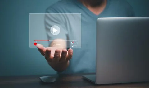 Young man using laptop computer with hand holding virtual playing video strea Stock Photos