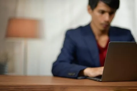Young Man Using Laptop at Desk in Professional Indoor Office Setting Stock Photos