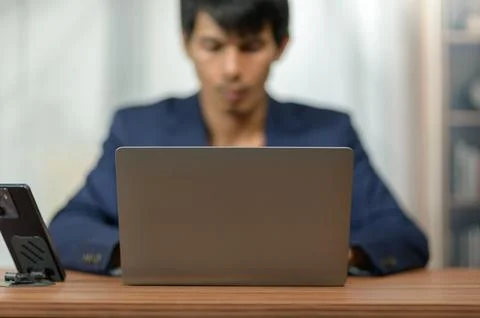 Young Man Using Laptop at Desk in Modern Office Environment Stock Photos