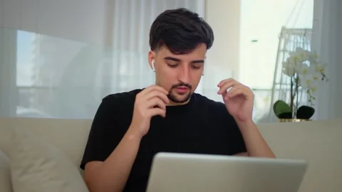 Young Man Using Laptop with Earphone at Home. Stock Footage 276978922