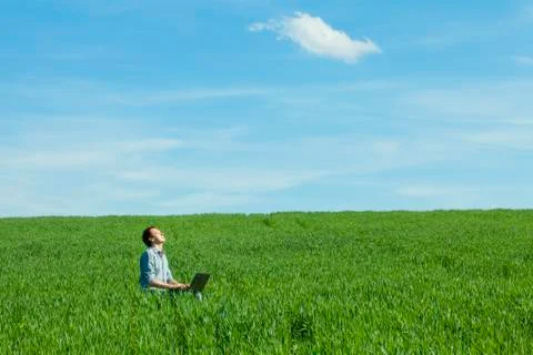 Young man using laptop in the field Foto stock