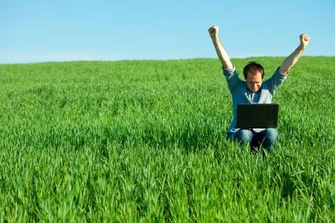 Young man using laptop in the field Foto stock
