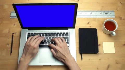 Young man using laptop with green screen at wooden desk. Top view on male hands Stock Footage 82895304