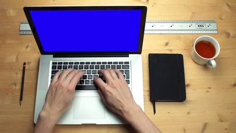 Young man using laptop with green screen at wooden desk. Top view on male hands Stock Footage 82896874