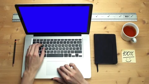 Young man using laptop with green screen at wooden desk. Top view on male hands Stock Footage 82897828