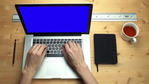 Young man using laptop with green screen at wooden desk. Top view on male hands Stock Footage 82897963