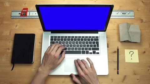 Young man using laptop with green screen at wooden desk. Top view on male hands Stock Footage 82898258