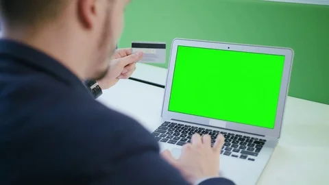 A Young Man Using a Laptop with a Green Screen Stock Footage 84767473