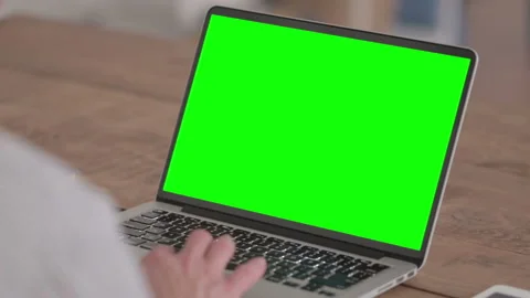 Young Man using Laptop with Green Screen Stockbeeldmateriaal 172037167