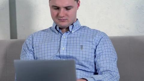 Young man using a laptop on his lap Stock-Footage 125899500
