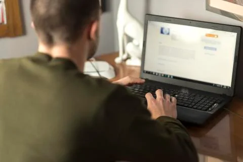 Young man using a laptop in his study room, cropped and close up Stock Photos