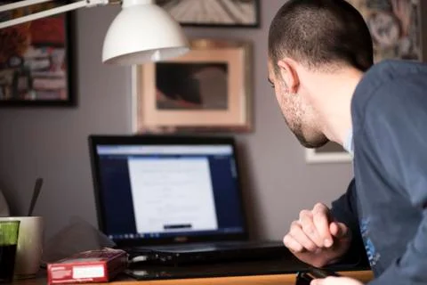 Young man using a laptop in his study room Stock Photos
