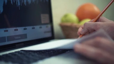 Young man using laptop at home. Analyzing graphs on laptop screen. Video stock 82934480