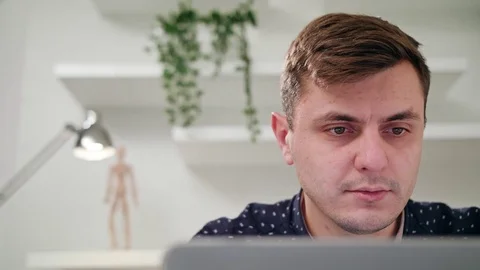 A Young Man Using a Laptop Indoors Stock Footage 83830369