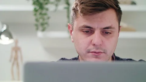 A Young Man Using a Laptop Indoors Stock Footage 83830458